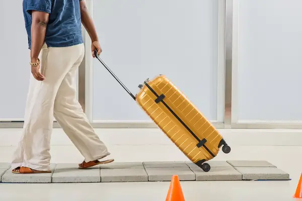 A person rolls the Samsonite Proxis Medium Spinner over stone pavers