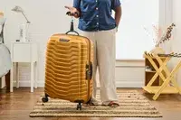 A person weighs the Samsonite Proxis Medium Spinner
