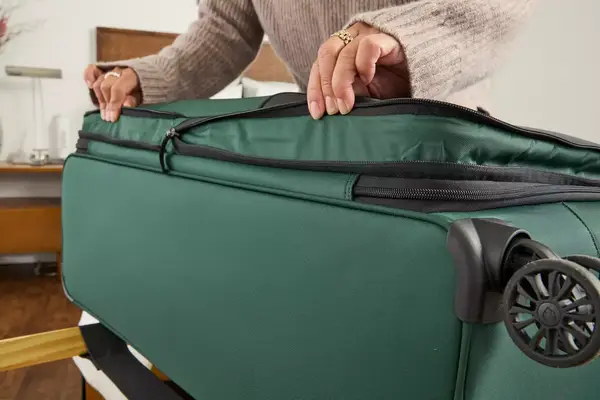 A person extends the Antler Soft Stripe Lightest Large Luggage