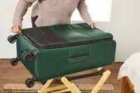 A person unzips the Antler Soft Stripe Lightest Large Luggage