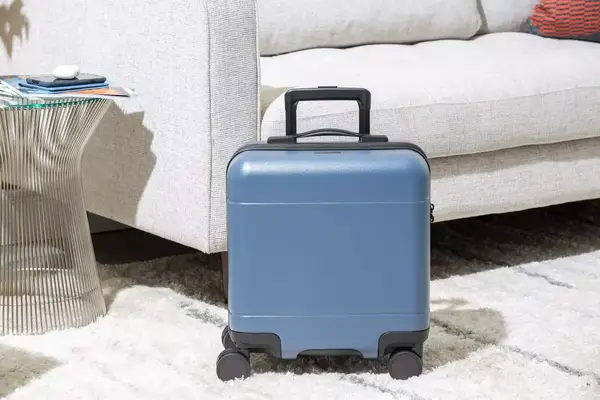 A person secures the strap on clothing packed in the Samsonite 21 Inch Freeform Hardside Expandable Carry-on Spinner