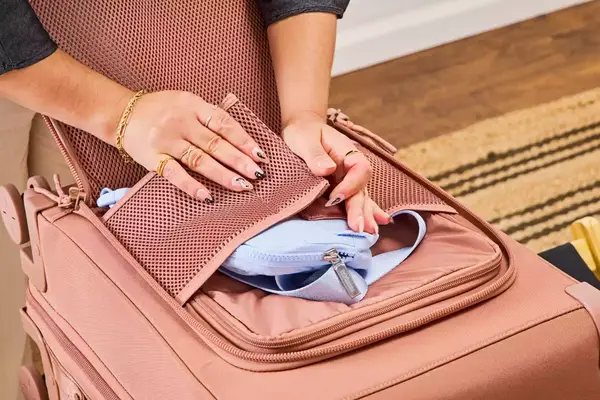 A person secures a waist pack in the Dagne Dover Smaller Seattle Carry-on Luggage 20.5 Inches
