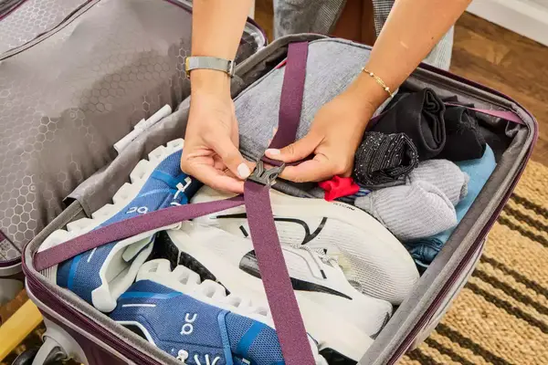 Person pulling a Samsonite Winfield 2 Hardside Luggage With Spinner Wheels over rocks