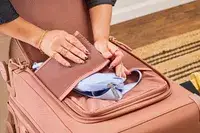 A person secures a waist pack in the Dagne Dover Smaller Seattle Carry-on Luggage 20.5 Inches