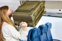 A person lifting the Dagne Doverr Seattle Carry On Rolling Luggage 20.5