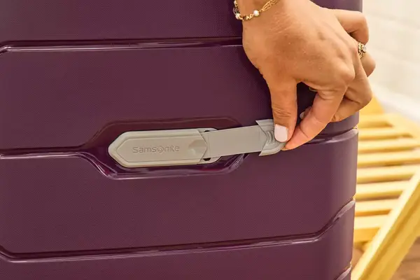 Samsonite Winfield 2 Hardside Luggage With Spinner Wheels being pulled over small rocks