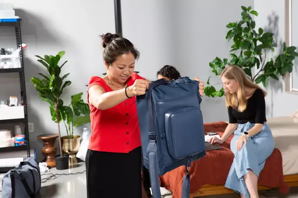 A person carrying the July Carry All Weekender by its shoulder strap