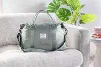 A person walking while holding the Longchamp Le Pliage Expandable Travel Bag in their hand