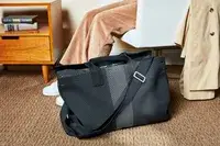 The Rothyâs The Weekender on a carpet next to a sitting person