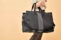 A person holding the Rothyâs The Weekender on their arm