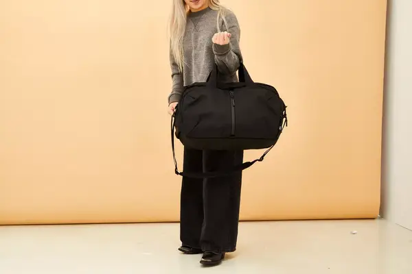 A person holding the Aer Travel Weekender on their arm