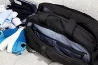 Clothes laying next to the Aer Travel Weekender