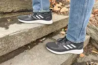 Person walking up stairs wearing gray Adidas Men