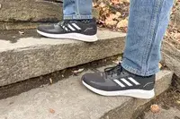 Person walking up stairs wearing gray Adidas Men