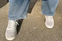 person standing on a concrete floor wearing Atoms Model 000