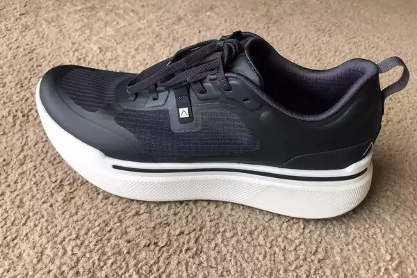 An AHNU Sequence 1 sneaker on carpet