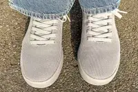 person standing on a concrete floor wearing Atoms Model 000