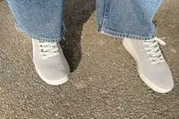 person standing on a concrete floor wearing Atoms Model 000