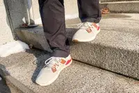 Person walking on concrete stairs wearing Olukai Mio Lī sneakers