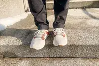 Person walking on concrete stairs wearing Olukai Mio Lī sneakers