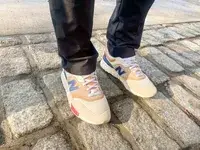 person wearing New Balance 997H V1 Sneakers on a brick floor