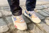 person wearing New Balance 997H V1 Sneakers on a brick floor
