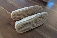 Two Beckett Simonon Leather and Suede Morgen Trainers posed on their side to show the shoes bottom on wood