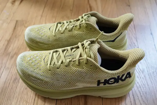The Hoka Clifton 9 sneakers on a wooden floor