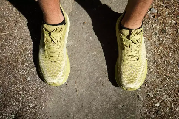 An arial-view of Hoka Clifton 9 sneakers worn on dirt