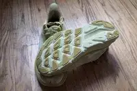 Two Hoka Clifton 9 sneakers posed on a wooden floor to show the bottom of the shoe