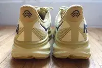 The back of two Hoka Clifton 9 sneakers on a wooden floor