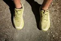 An arial-view of Hoka Clifton 9 sneakers worn on dirt