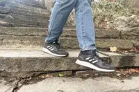 Person walking down stairs wearing gray Adidas Men