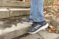 Person walking up stairs wearing gray Adidas Men
