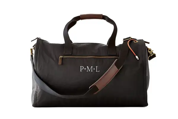 Béis The Weekender Travel Bag placed on the carpet next to table