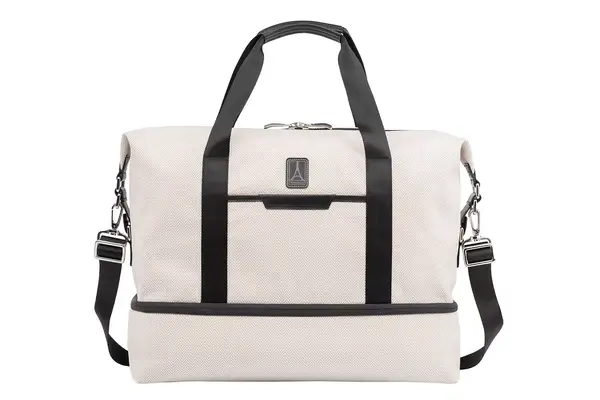 A person walking while holding the Cotopaxi Viaje 35L Weekender Bag - Cada Día