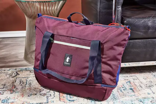 Cotopaxi Viaje 35L Weekender Bag - Cada Día on the floor next to furniture