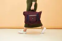 A person walking while holding the Cotopaxi Viaje 35L Weekender Bag - Cada Día