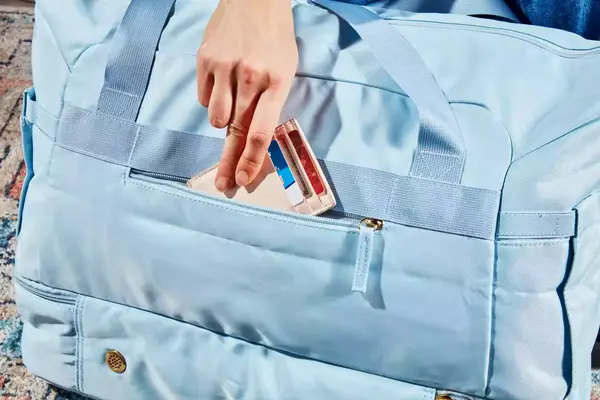 A hand slipping a wallet into the ETRONIK Large Overnight Weekender 55L