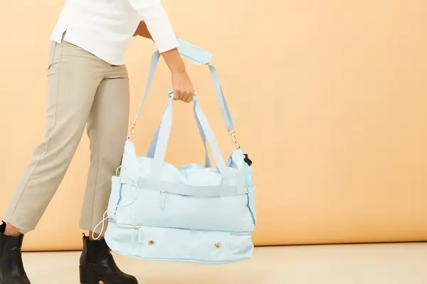 A person holding both handles of the ETRONIK Large Overnight Weekender 55L