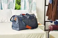 Mark & Graham Commuter 2-in-1 Garment Bag on a bed