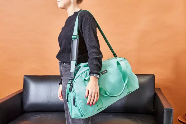 A person carries the Arlo Skye The Weekender on their shoulder