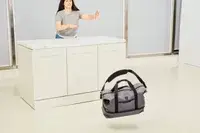 A person pushing the Travelpro x Travel & Lanetrek Drop-bottom Weekender Bag off of a counter