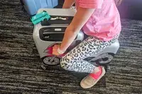 A child sitting on the Younglingz Ride On Suitcase