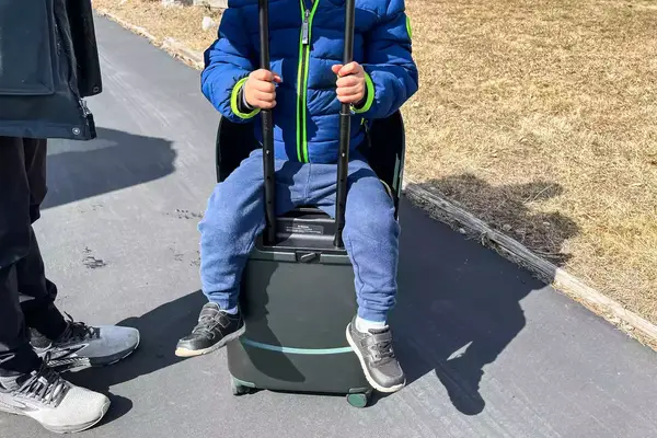 A person sitting on the MiaMily Carry-On 
