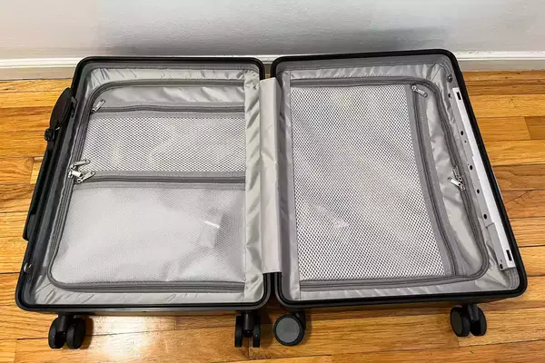 An opened, empty MiaMily Carry-On on a wooden floor