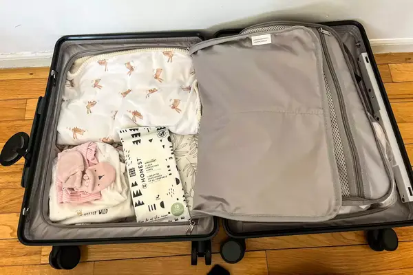 An opened MiaMily Carry-On on a wooden floor