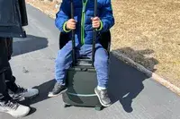 A person sitting on the MiaMily Carry-On 