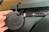 A hand holding a tag on the MiaMily Carry-On