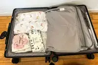 An opened MiaMily Carry-On on a wooden floor